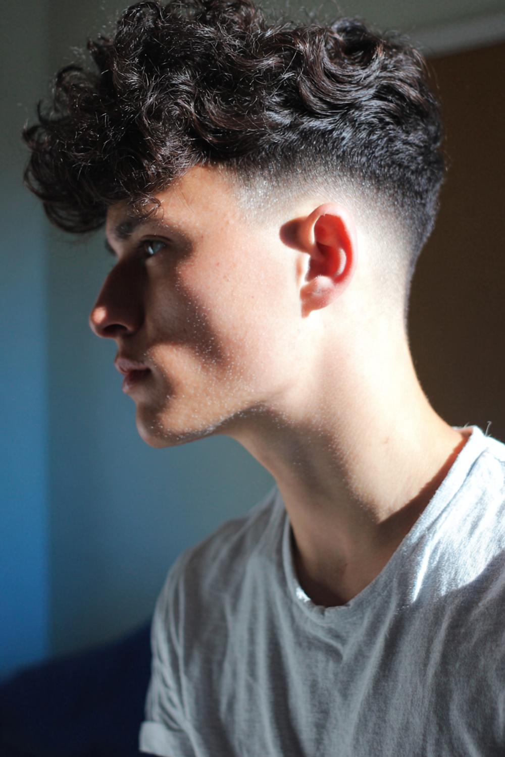 4. Frisuren 2026 Männer: Curly Top mit Low Taper Fade