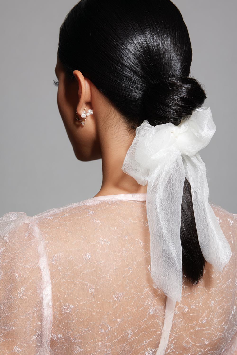 5. Frühlingsfrisuren 2026: Sleek Low Bun mit zarter Schleife aus Organza