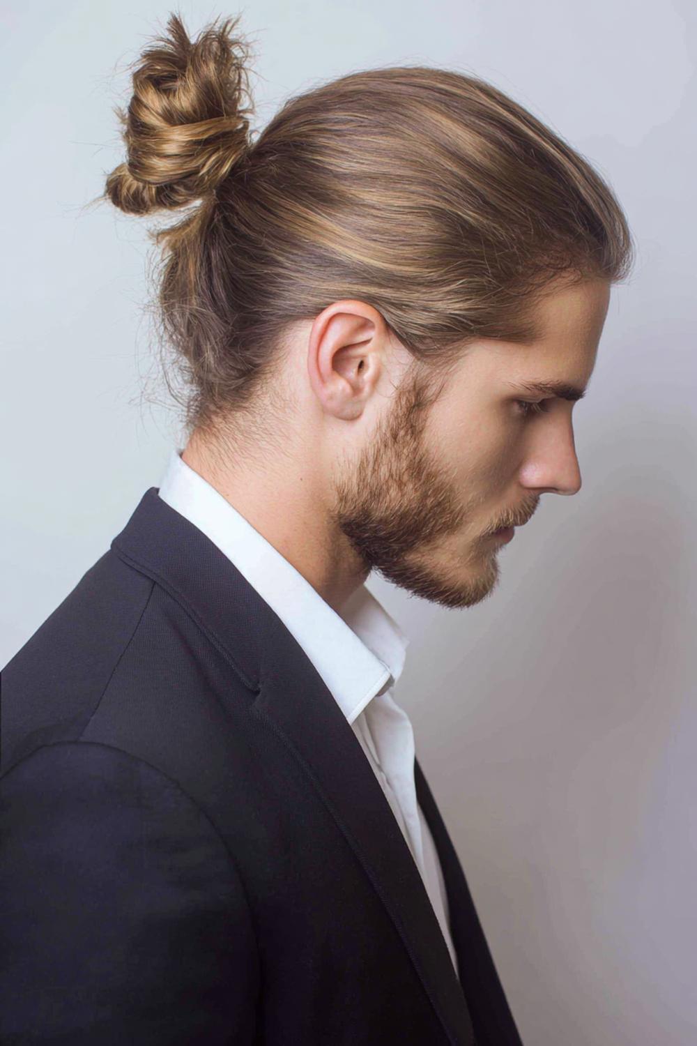 24. Männer Frisuren 2026: Man Bun mit glattem Ansatz und lockerem Knoten am Hinterkopf