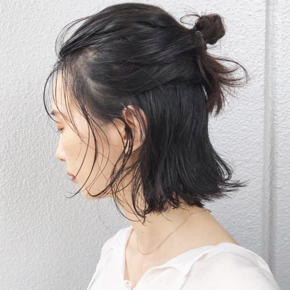 Kleiner Messy Bun bei kurzem braunem Bob