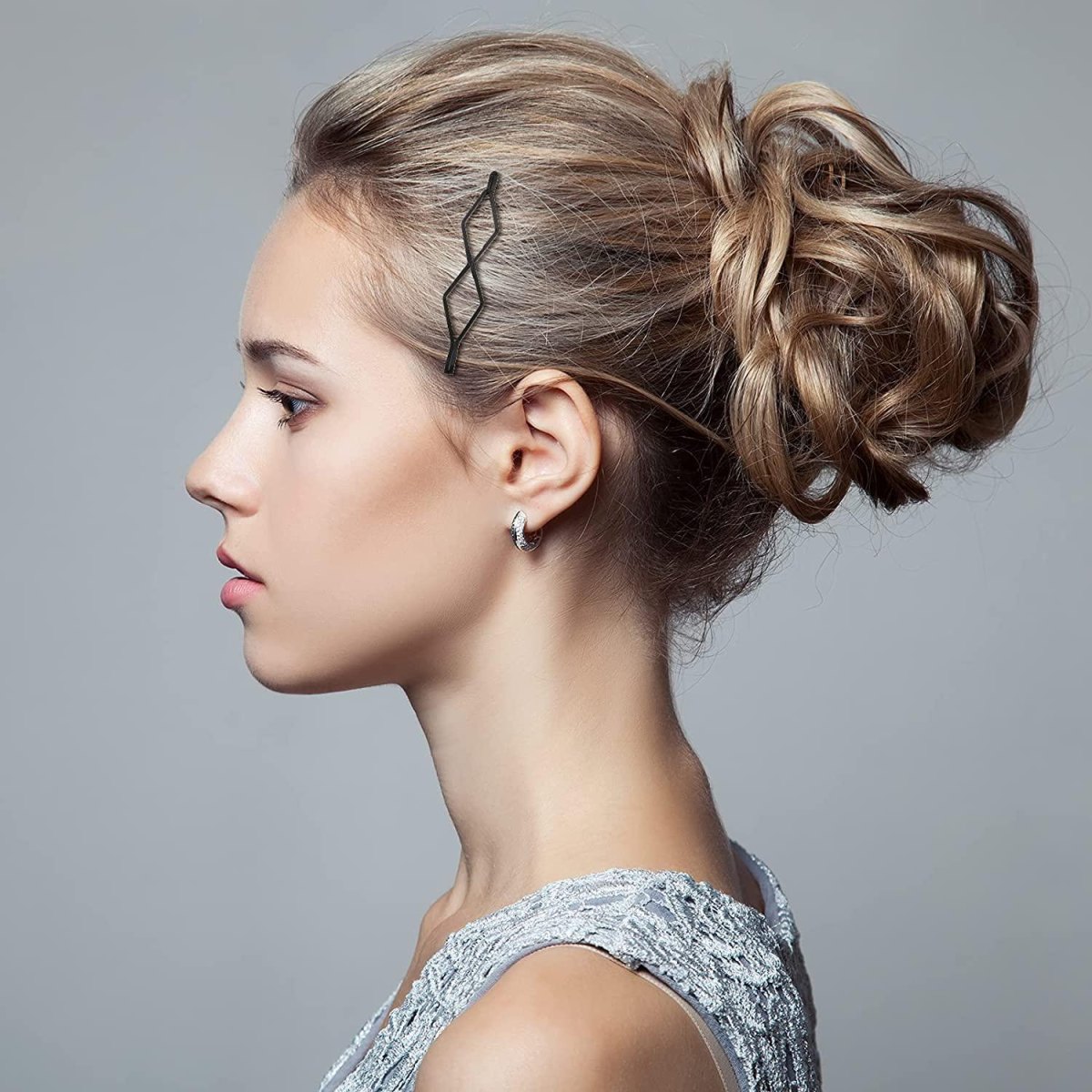 Blonder Messy Bun mit Haargummi und dezenten Haarspangen