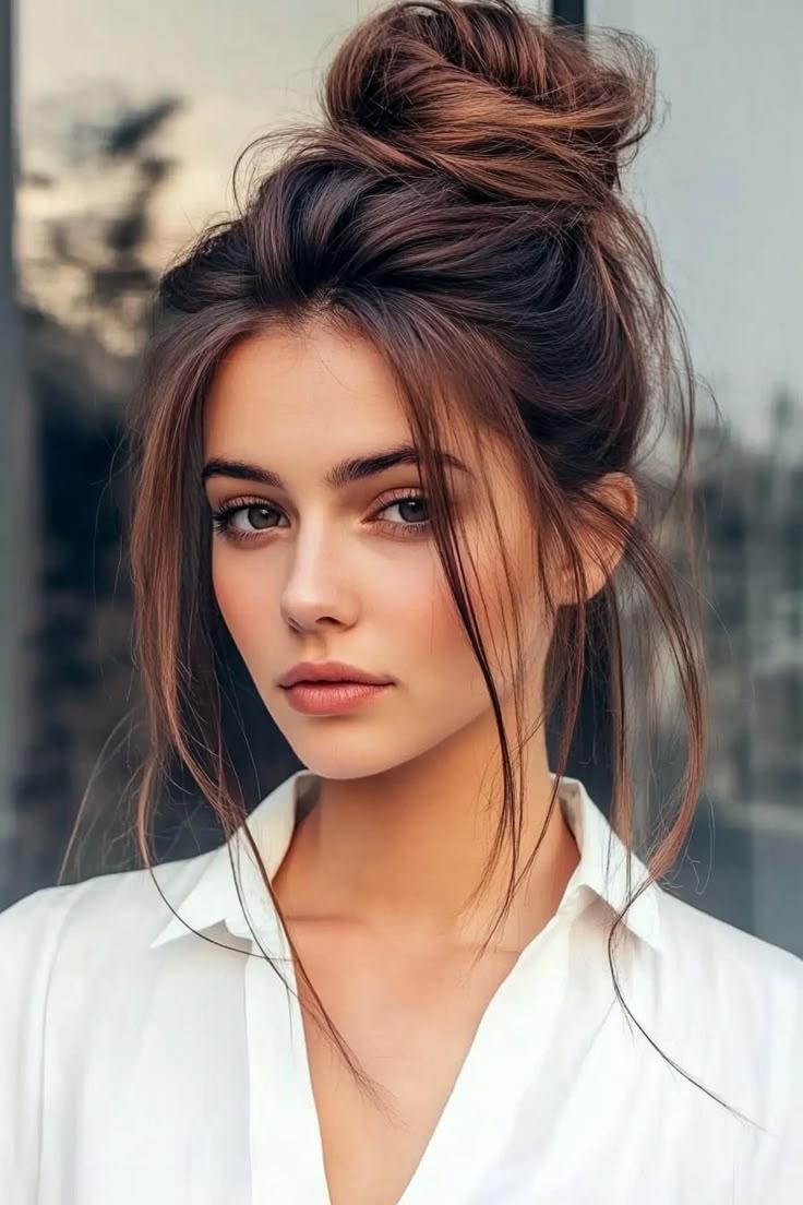 Brauner Messy Bun mit seitlichem Scheitel und losen Strähnen