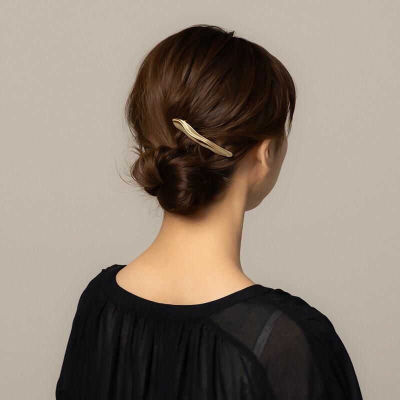 Goldene Haarspange am kurzen Low Bun