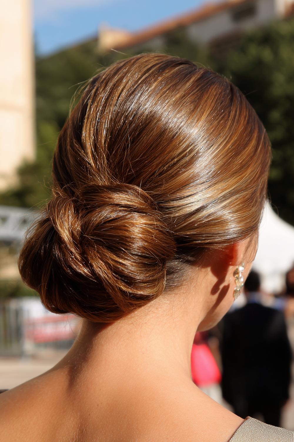 1. Sleeker Low Bun Frisur mit Mittelscheitel und Glanz-Finish