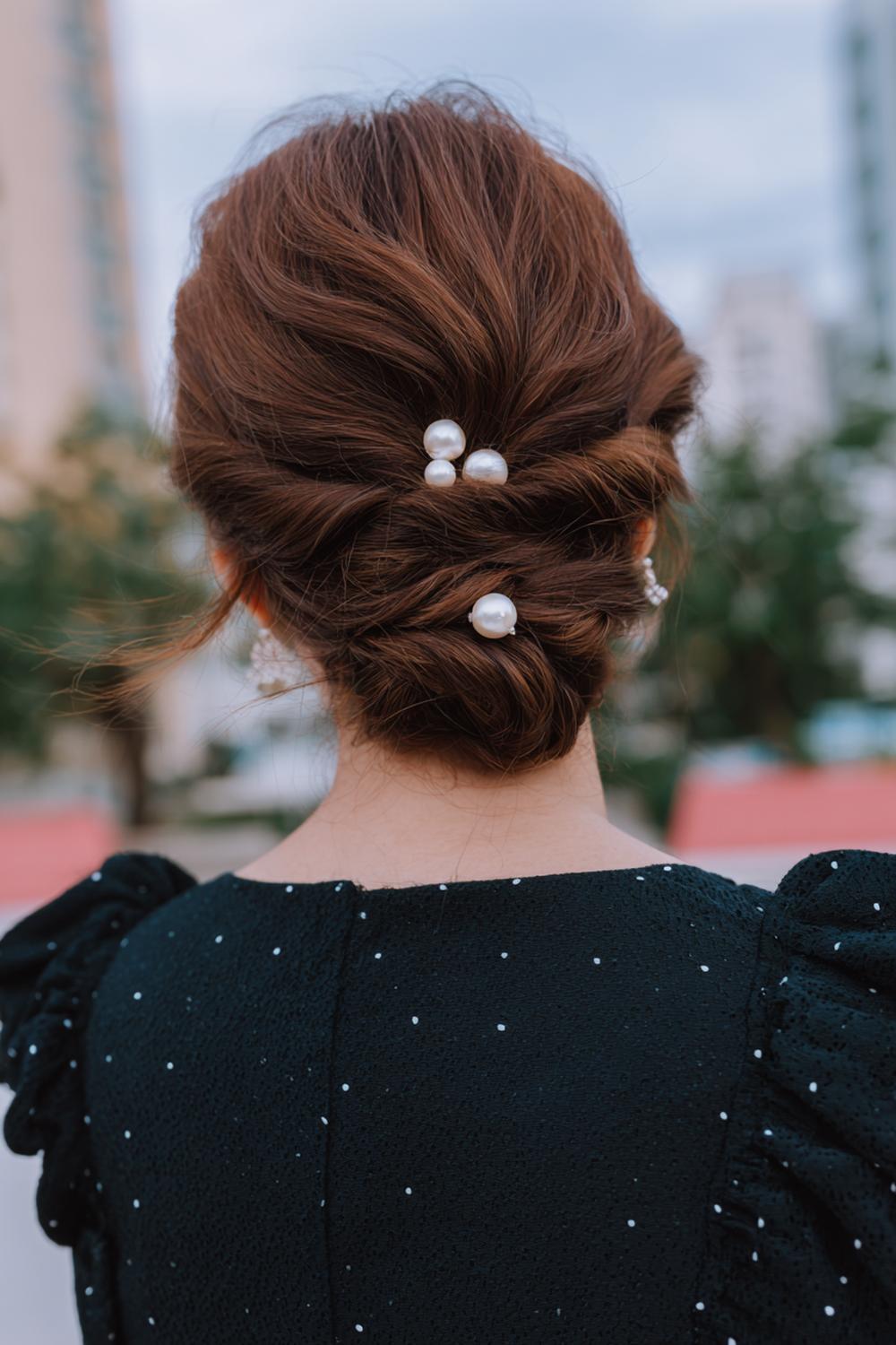 9. Twisted Low Chignon Frisur mit zwei Drehsträhnen und Perlenpins